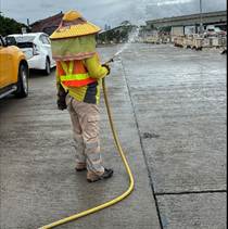 A person wearing a yellow vest and a hat spraying water
AI-generated content may be incorrect.